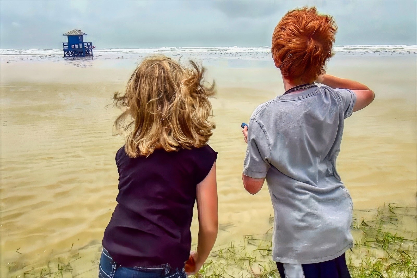 Two children standing on a Siesta Beach watching distant storm clouds before Tropical Storm Debby landfall