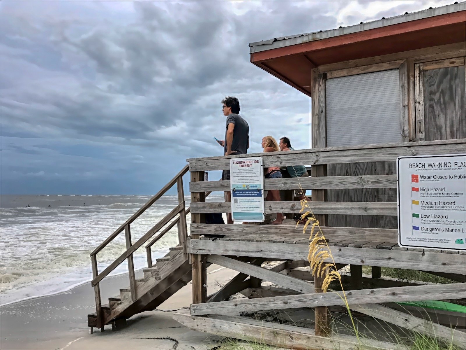People watching powerful waves from raised lifeguard tower before Hurricane Milton in Sarasota Florida