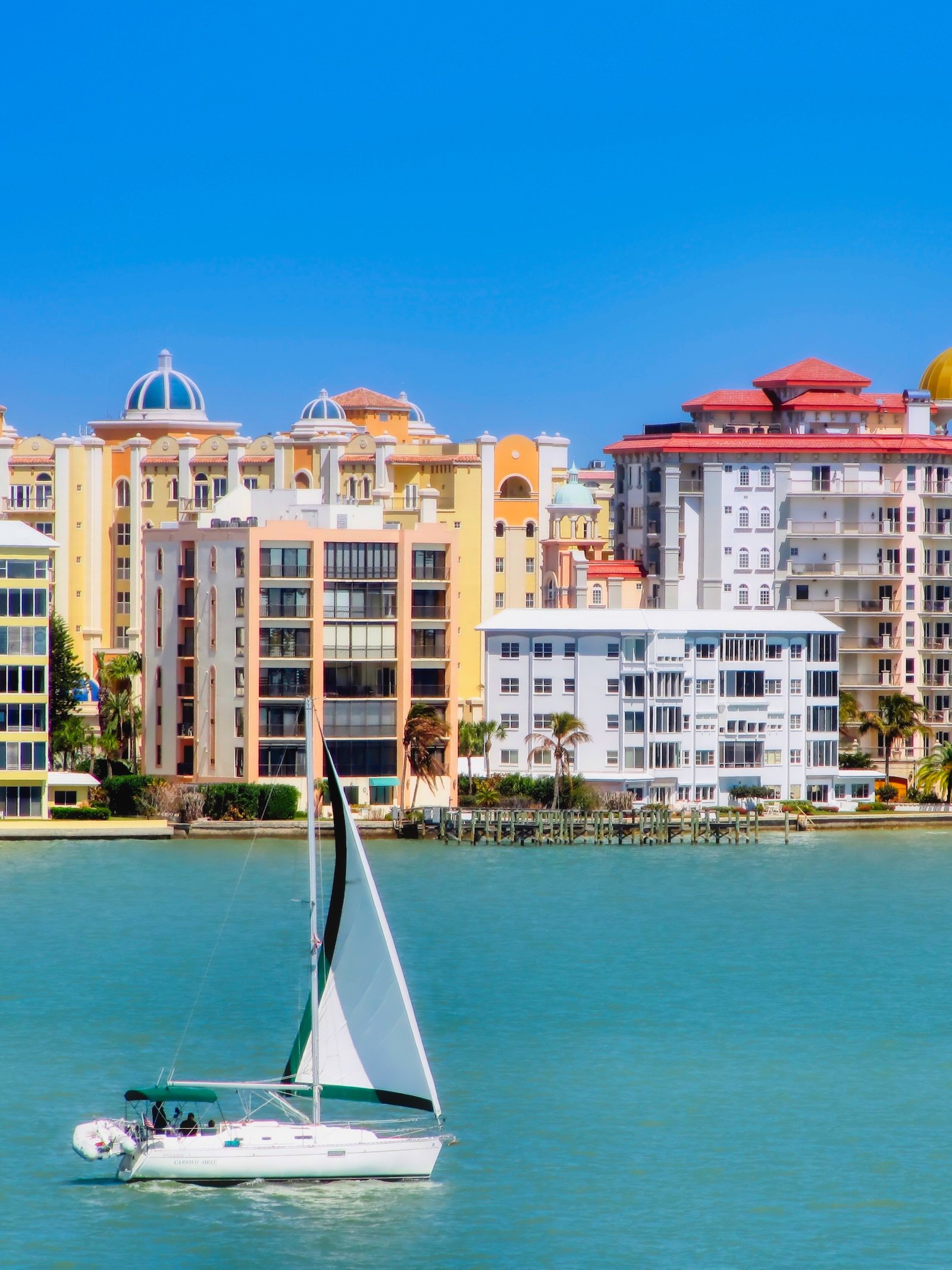 If you prefer slower boats, a sailboat chugging along in Sarasota Bay against a backdrop of Golden Gate Point may be exactly what your travel agent planned.