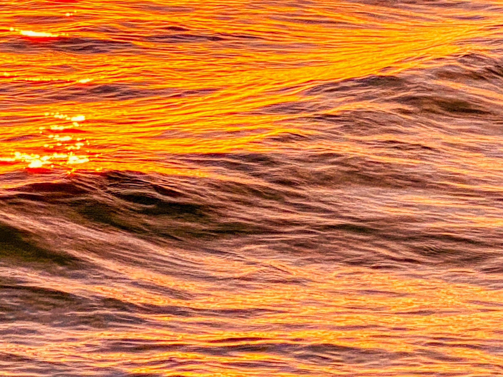 Setting sun radiates off the gentle Gulf waves in Sarasota, Florida
