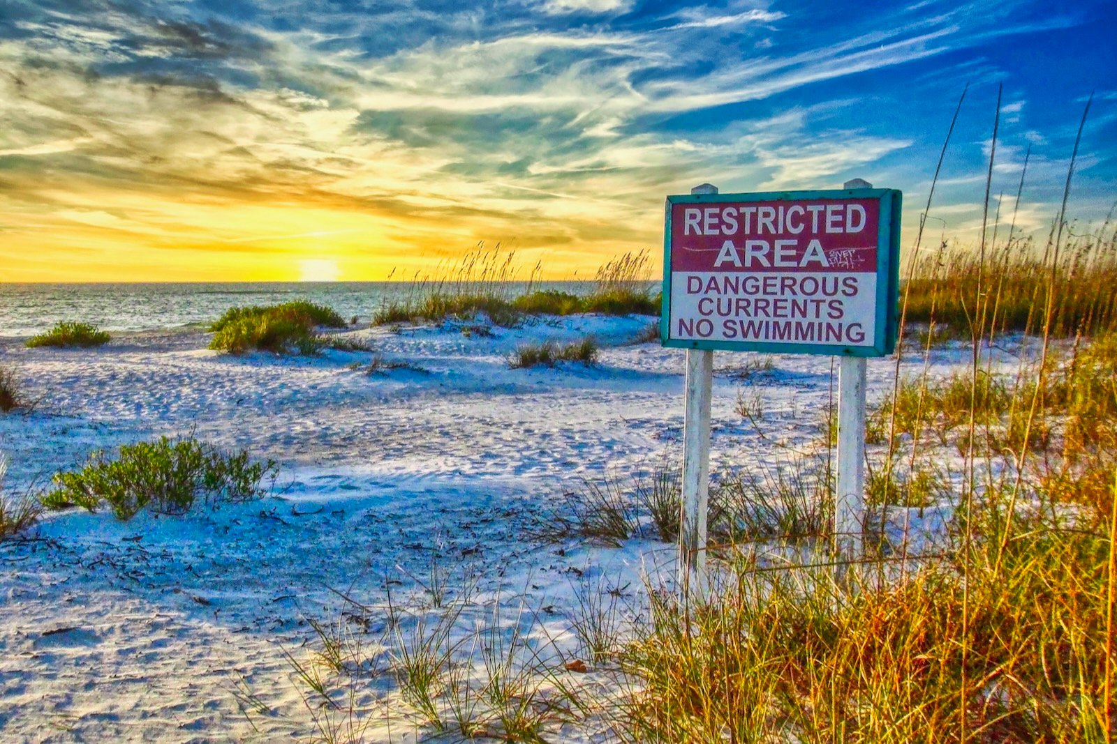 Big billboard-sized sign at South Lido Beach Florida reads, "Restricted Area: Dangerous Currents. No Swimming."