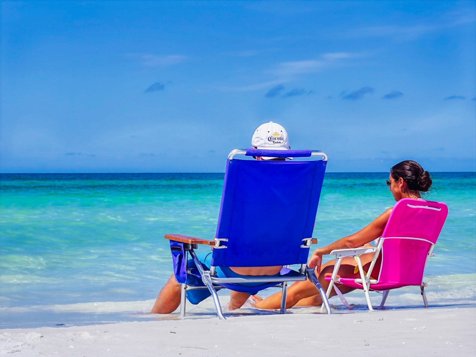 Young couple sitting at the water's edge chose the best time of year to visit Sarasota beaches